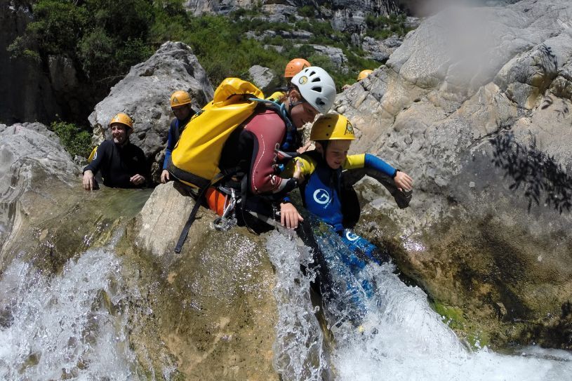 Fotografía de monitora y niño en Sierra de Guara realizando barranquismo en grupo
