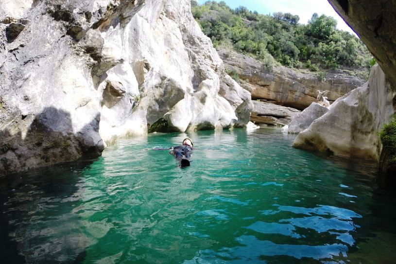 Fotografía de actividad de barranquismo en Sierra de Guara, hombre descansando en el agua